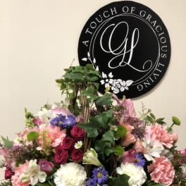 Mixed pink, white, and purple flowers in a wicker basket arrangement
