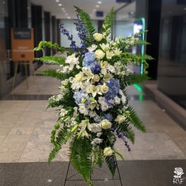 Tall standing floral spray with white, blue, and purple flowers
