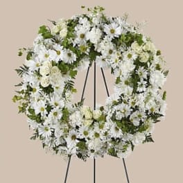 White floral wreath on a black stand