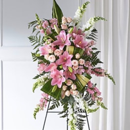 Standing floral spray with pink lilies and roses on an easel