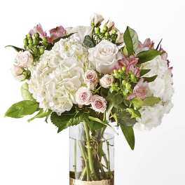 White and blush bouquet in a clear glass vase