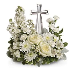 White floral arrangement with a silver cross centerpiece