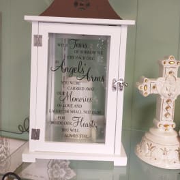 White memorial lantern with a sympathy quote and a decorative cross beside it