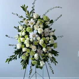 Standing floral spray of white roses and lilies with green accents
