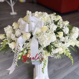 White floral arrangement with roses and hydrangeas on a pedestal stand