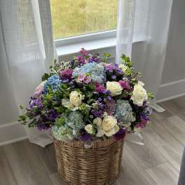 Large mixed flower arrangement in a woven basket