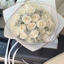 Bouquet of cream roses wrapped in white paper