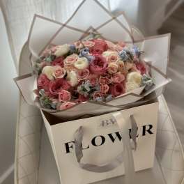 Bouquet of pink and cream roses in a gift bag