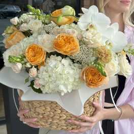 Bouquet of white and peach flowers in a woven basket