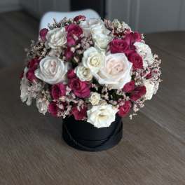 Bouquet of white and magenta roses in a black hat box