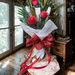 Tall bouquet of red roses with decorative greenery and a plaid ribbon