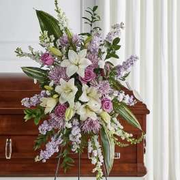 Large floral spray with white lilies and pink roses on a casket