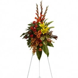 Standing floral spray with red and yellow flowers on an easel