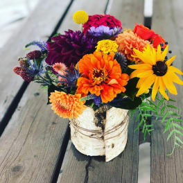 Colorful mixed bouquet in a birch bark container
