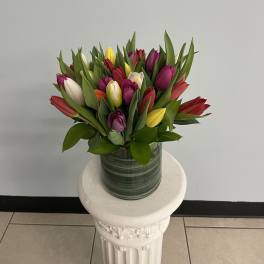 Colorful tulip bouquet in a striped glass vase