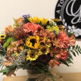 Mixed bouquet of sunflowers, chrysanthemums, and alstroemeria in a vase