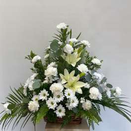 White lilies and daisies in a wicker basket arrangement
