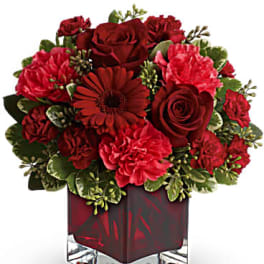 Red roses and carnations in a square glass vase