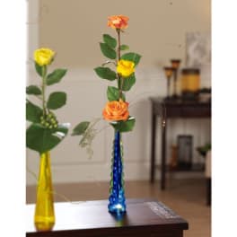 Two single-stem rose arrangements in tall colored glass vases