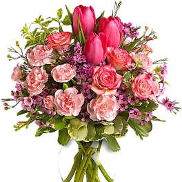 Pink tulips and roses arranged in a clear glass vase