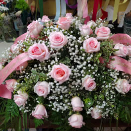 Large pink rose arrangement with baby’s breath and pink ribbons