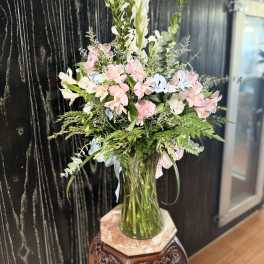 Tall bouquet of pink and white flowers in a clear glass vase