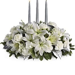White floral centerpiece with three tall candles