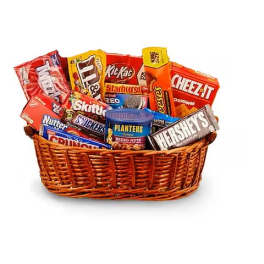 Wicker basket filled with assorted candy bars, snack packs, and a can of nuts.