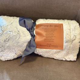 Two folded plush blankets tied with a ribbon and prayer tag