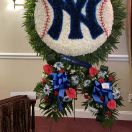 Large floral tribute shaped like a baseball with a Yankees logo