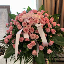Pink rose funeral spray with a "Beloved Mother" ribbon
