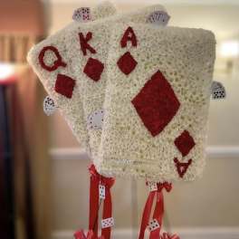 Floral arrangement shaped like playing cards with red suit symbols