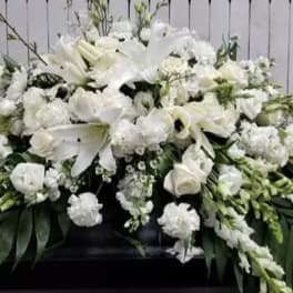Large white funeral spray with lilies and roses