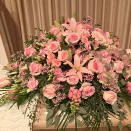 Large pink floral casket spray with roses and lilies