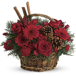 Red roses and gerbera daisies in a wicker basket with pinecones