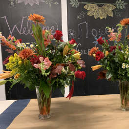 Two colorful mixed flower arrangements in clear glass vases