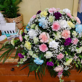 Large casket spray of pastel carnations with baby's breath