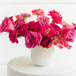 Pink and magenta mixed bouquet in a white textured vase
