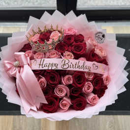 Bouquet of pink and red roses with a Happy Birthday ribbon and crown