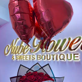 Bouquet of red roses with heart-shaped balloons and a birthday ribbon