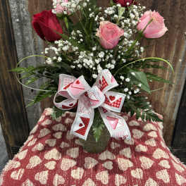 Bouquet of pink and red roses with baby's breath and a heart ribbon