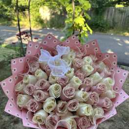 Bouquet of pale pink and cream roses wrapped in pink paper