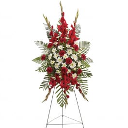 Tall standing spray of red and white flowers on a metal easel