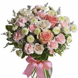 Vase arrangement of pink and white roses, carnations, and mums with a pink ribbon bow