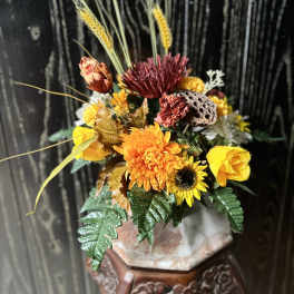 Autumn floral arrangement with yellow and orange blooms in a vase