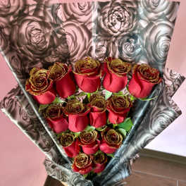 Bouquet of red roses wrapped in black-and-silver floral paper
