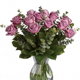 Lavender roses arranged in a clear glass vase