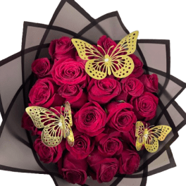 Round bouquet of deep red roses wrapped in black paper with three gold butterfly decorations.
