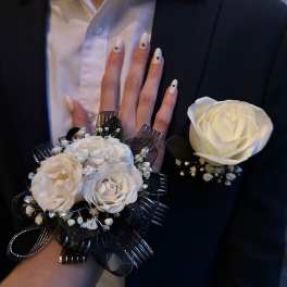 White rose corsage and boutonniere on a black suit jacket