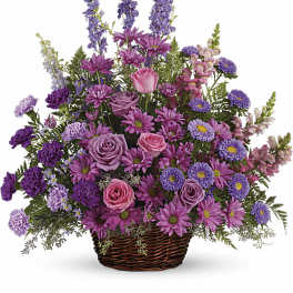 Fan-shaped basket arrangement of pink roses, purple daisies, carnations, asters and delphinium.